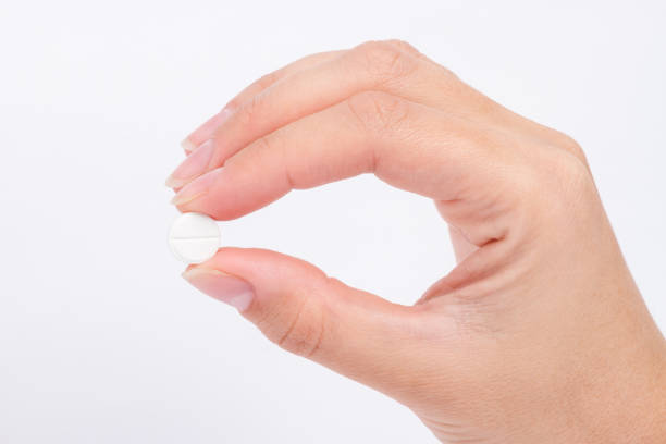 istock doctor's hand holds the white pill close-up 864544874