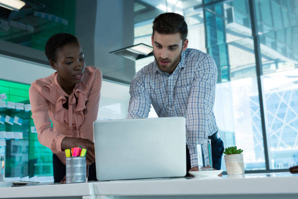 istock Executives discussing over laptop at desk 864545682