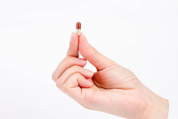 istock doctor's hand offers capsule with granules 864546198