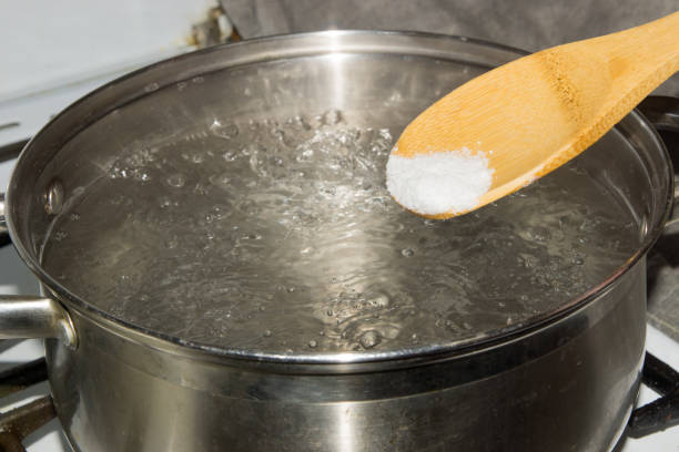 istock In boiling water pour salt with a wooden spoon. 864547960