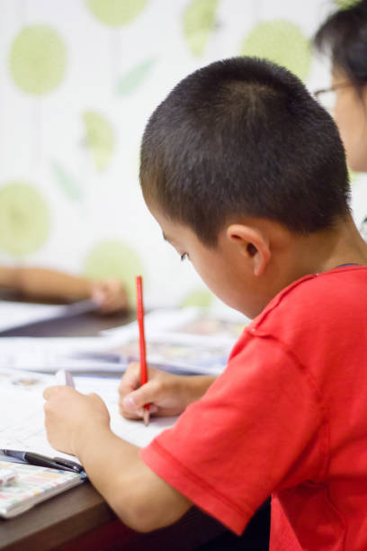 istock Boy sitting next to his mom doing his homework 864548522