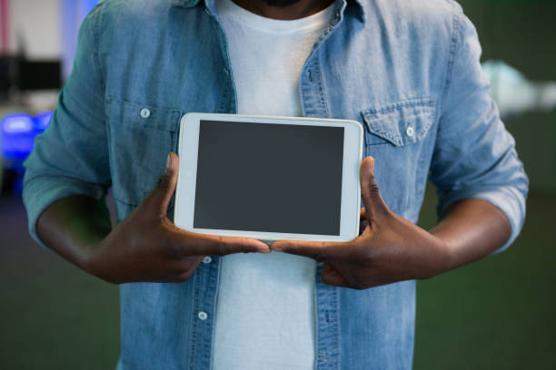 istock Mid section of male executive holding digital tablet 864549026
