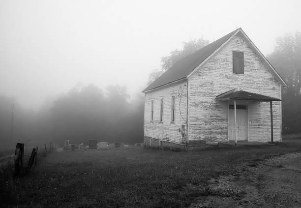 An old abandoned church and it's graveyard in the morning fog