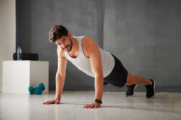istock Man planking in the gym 864549500