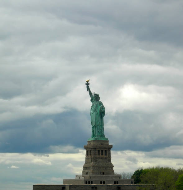 istock Statue of liberty seen from the front with a grey and cloudy sky. 864551252