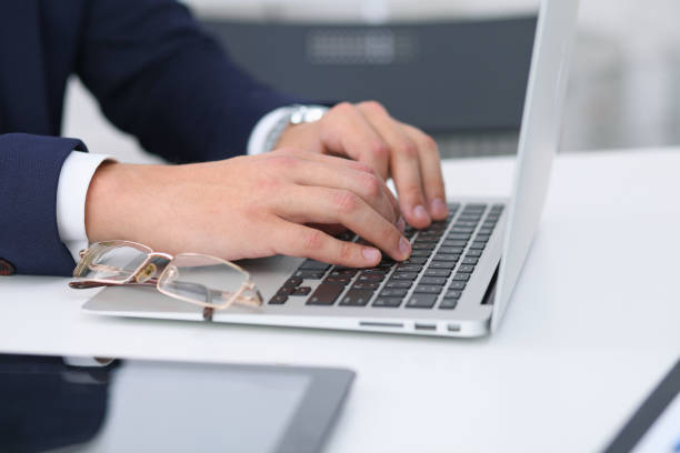 istock Businessman working by typing on laptop computer. Man's hands on notebook or business person at workplace. Employment  or start-up concept 864551916