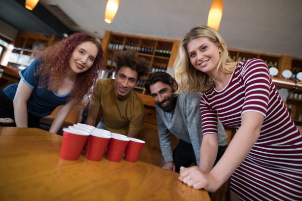 istock Smiling friends standing near beer pong on table 864553600