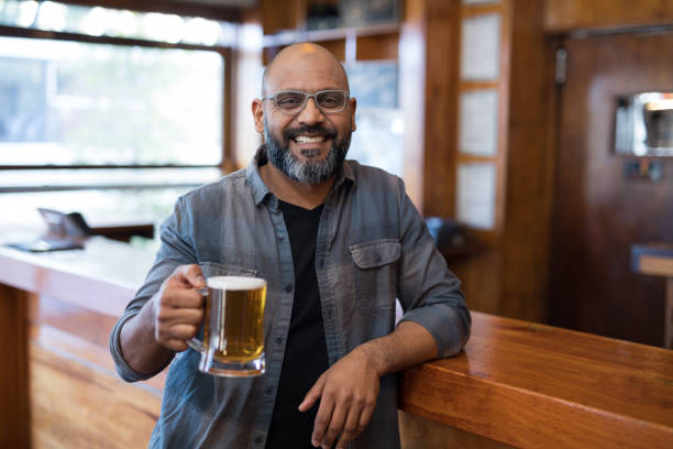 ビールのグラスを持って幸せな男のバー - beer bar counter bar beer glass ストックフォトと画像