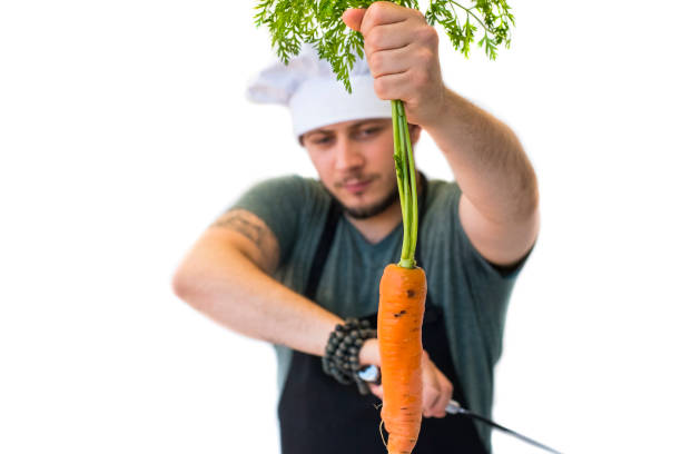 Chef preparing to cut a carrot