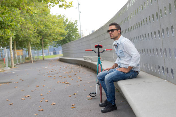 istock Young man biker relaxing on a bench while listening music 864557004
