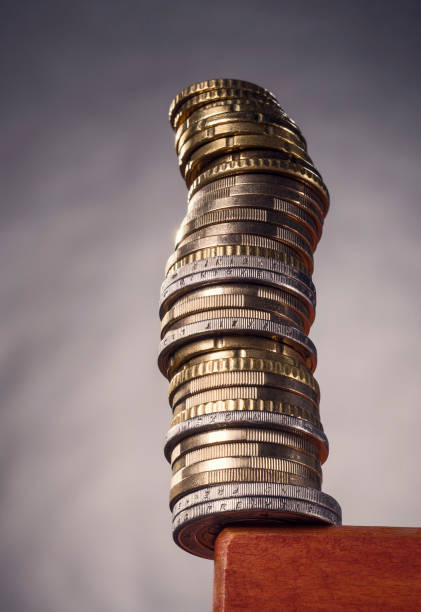 Stack of coins on a table edge stock photo