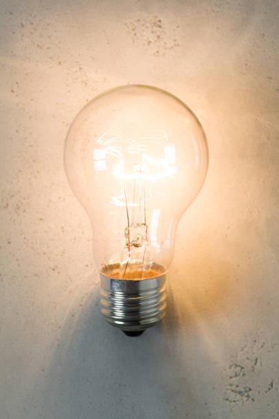 istock Vintage incandescent bulb on concrete background 864559196