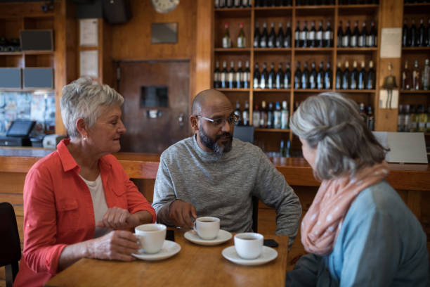 istock Happy friends interacting while having cup of coffee 864560154