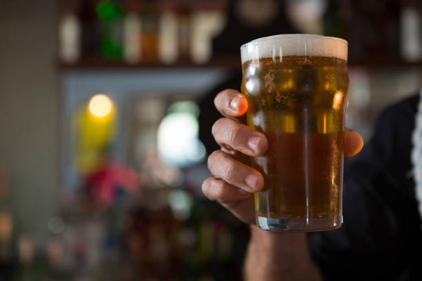 istock Portrait of bar tender offering beer 864561582