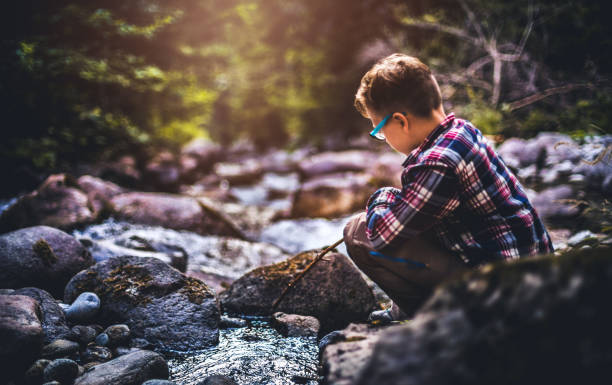 istock A boy sitting near water stream and watching forward 864561590