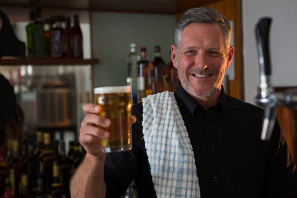 istock Portrait of bar tender offering beer 864561604