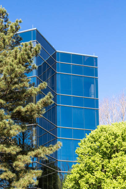 istock Blue Glass Tower Behind Green Trees 864562508