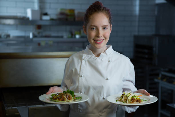 istock Female chef holding food plate 864565234