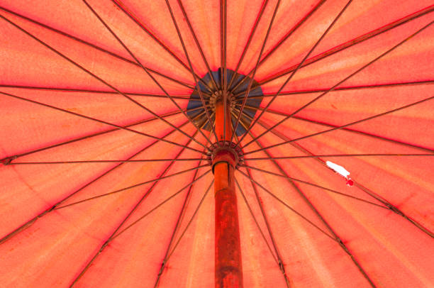 istock Closeup to Under Bamboo Orange Red Umbrella 864566324