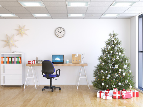 Laptop on table, Christmas tree and gifts on background