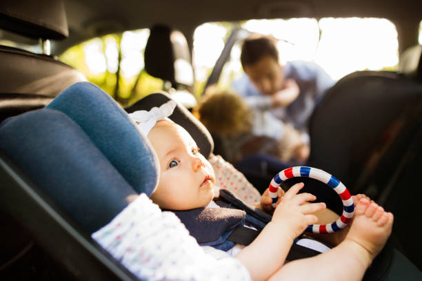 寶貝的小女孩用安全汽車座椅安全帶緊固。 - 嬰兒安全座椅 圖片 個照片及圖片檔