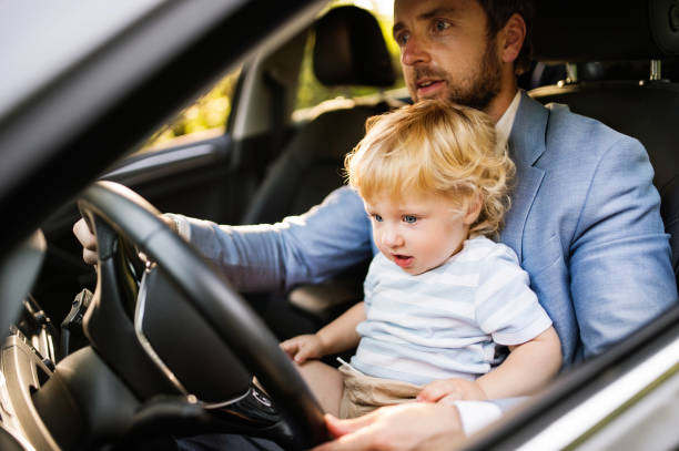 istock Man driving a car with little son. 864570028
