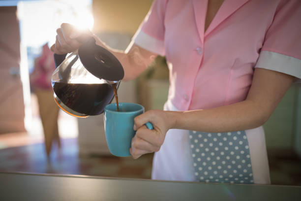 Pouring coffee on a cup isolated on white background
