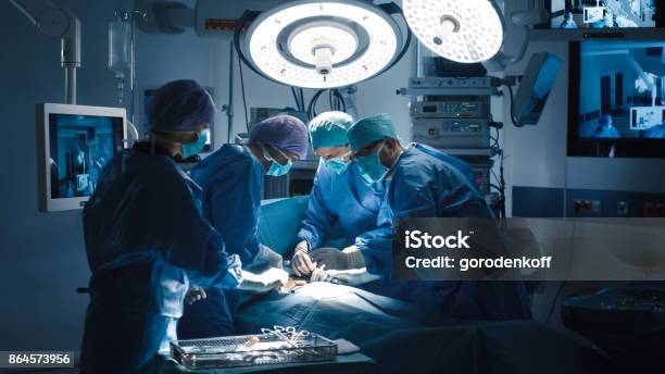 Medical Team Performing Surgical Operation In Modern Operating Room Stock Photo - Download Image Now