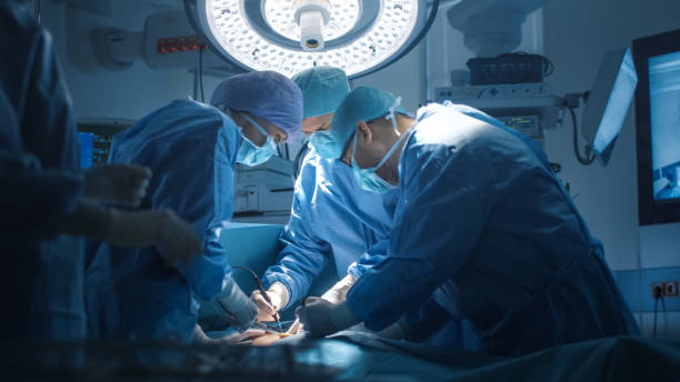 cerrar tiro de médicos equipo realizar operación quirúrgica en quirófano moderno - performance surgery doctor men fotografías e imágenes de stock