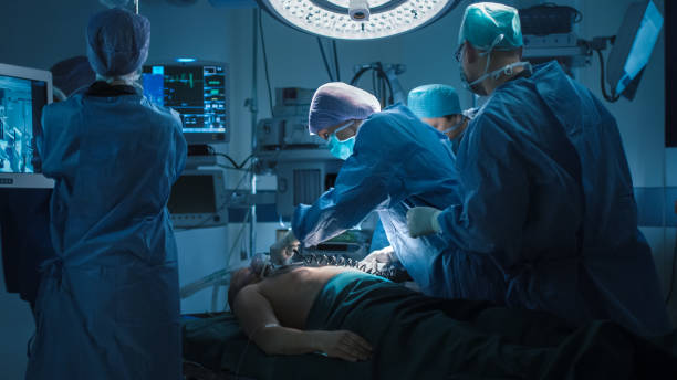 equipo médico realizar desfibrilación, en quirófano moderno. - performance surgery doctor men fotografías e imágenes de stock