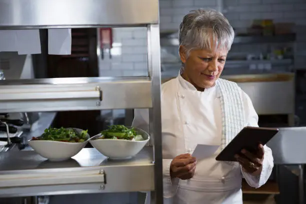 Photo of Female chef holding digital tablet