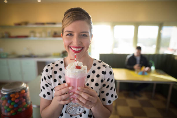 istock Woman having milkshake in restaurant 864577594