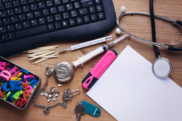 doctor office desktop, black keyboard and stethoscope,thermometer,syringe,colorful letters,pocket watch, tooth stick and key