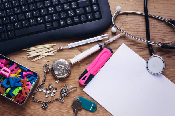 doctor office desktop, black keyboard and stethoscope,thermometer,syringe,colorful letters,pocket watch, tooth stick and key - letter c imagens e fotografias de stock