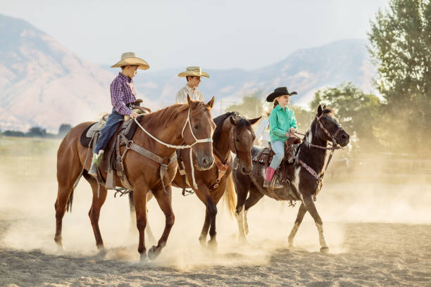 istock Young Rodeo Cowboys Riding in a Row 864580582