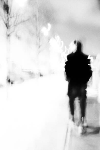 Silhouette of a man Silhouette of a man walking in the night city. High contrast black and white photo. pavement ends sign stock pictures, royalty-free photos & images