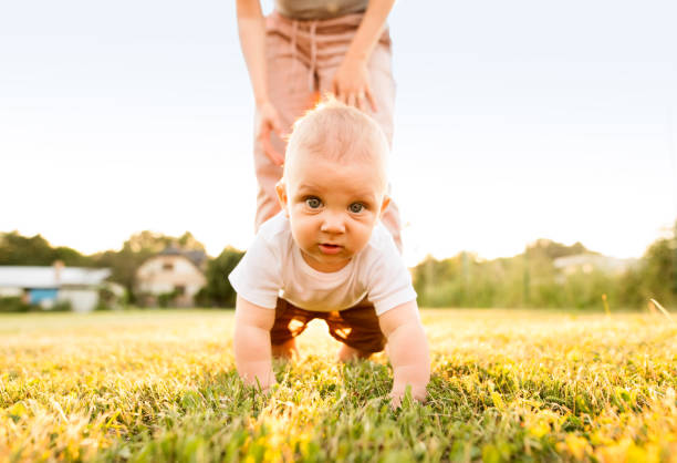 istock Baby boy with unrecognizable mother crawling outside. 864582124