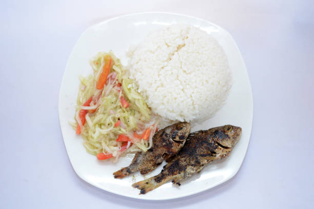 Grilled fish with white rice and pickled papaya and tomato.