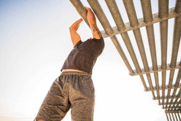istock Chin-ups Outdoor - Man working out using pipes 864583146