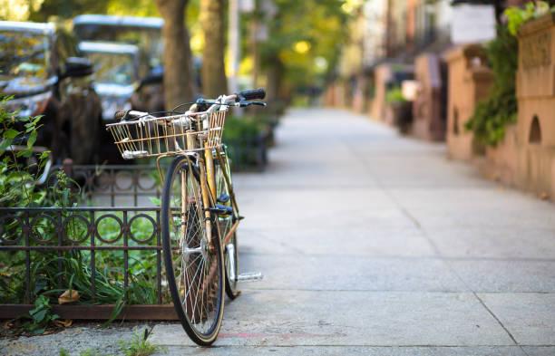 A bicycle leaning against a wrought iron fence in Brooklyn.