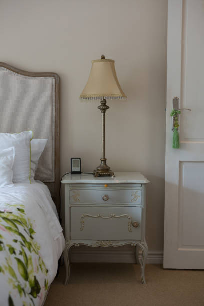 istock Lamp on wooden bedside table in bedroom 864586326