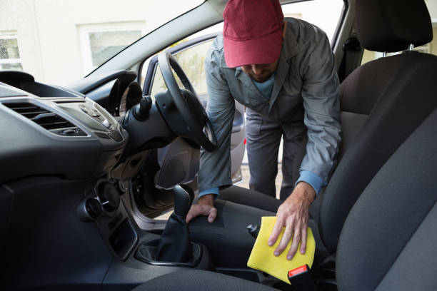 istock Worker cleaning seat inside the car 864587118