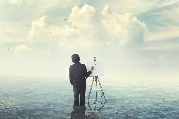 painter with brush with canvas easel finding insiration in water painter with brush with canvas easel finding insiration in water calm before the storm photos stock pictures, royalty-free photos & images