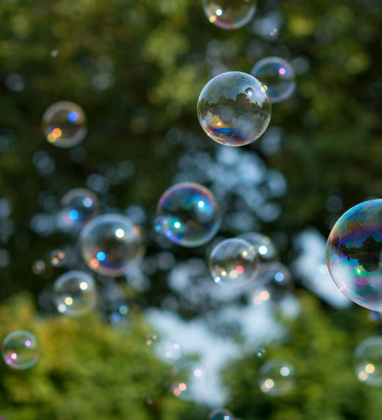 istock Soap bubbles flying in front of trees in sunlight 864590184