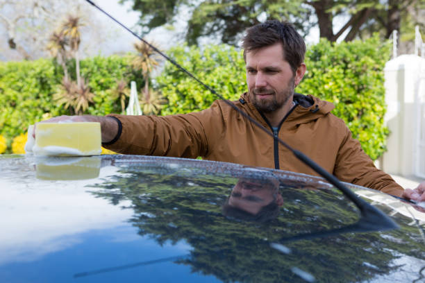 istock Auto service staff washing a car roof with sponge 864591814