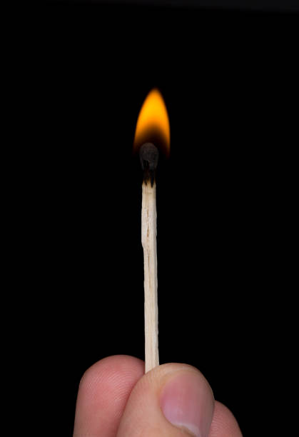 istock Close-Up Of Burning Match On Black Background 864591918