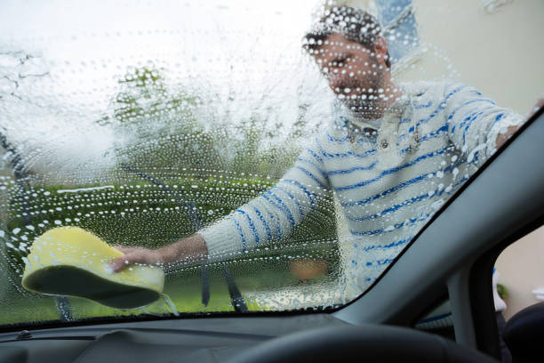 istock Auto service staff washing a windscreen with sponge 864593272