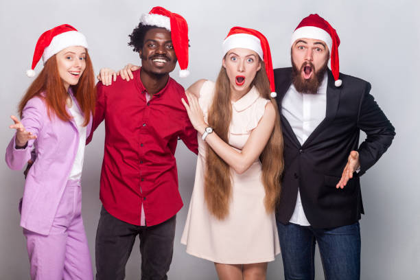 istock Well dressed amazed workers in christmas hat looking at camera with shocked face 864593518