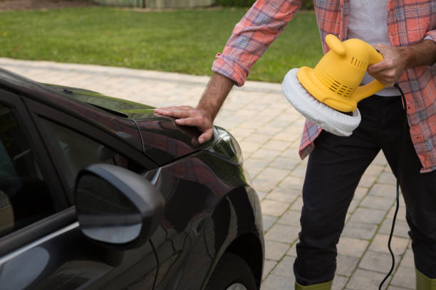 istock Auto service staff cleaning a car with rotating wash brush 864594100