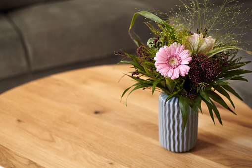 A small bouquet of flowers that stands in the secret living room on a small round wooden table.